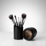 Icon showing makeup brushes and camera lens for professional photo shoot makeup service at LaturMakeup, sleek and modern design.